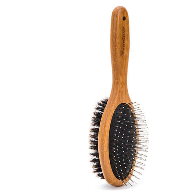 Double-sided dog cleaning brush with wooden handle for removing dirt and loose fur during grooming sessions.