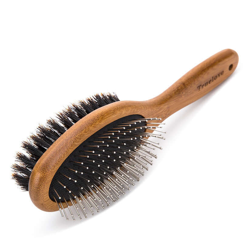 Double-sided dog cleaning brush with wooden handle and soft bristles for removing dirt and loose fur.