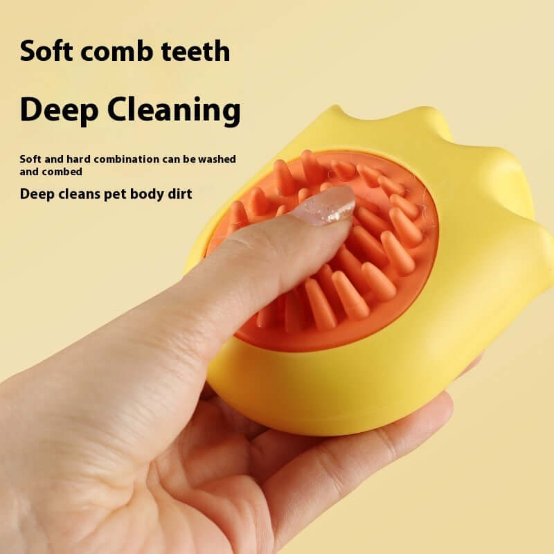 Yellow pet bath brush with soft comb teeth for deep cleaning, designed for cat and dog massage, held in hand against a light background.